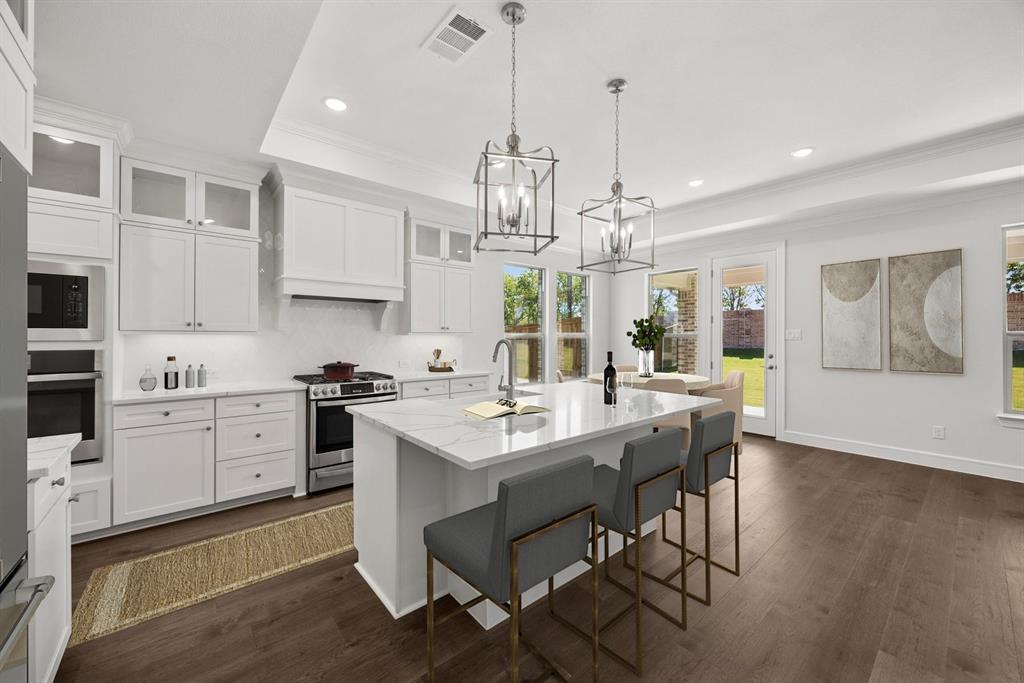 1317 Benjamin Trail Van Alstyne, TX 75495 - Photo 4 of 29 a kitchen with a stove a sink a dining table and chairs