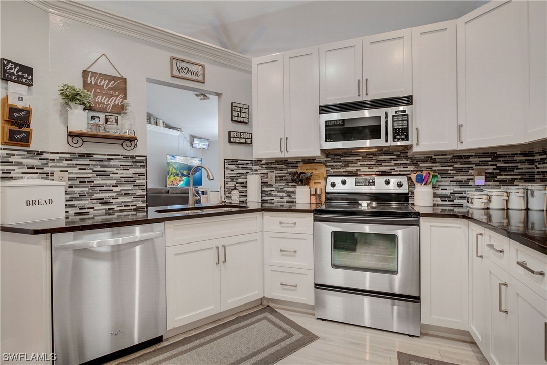 8337 Robin Road Fort Myers, FL 33967 - Photo 3 of 36 a kitchen with stainless steel appliances granite countertop a stove and a microwave