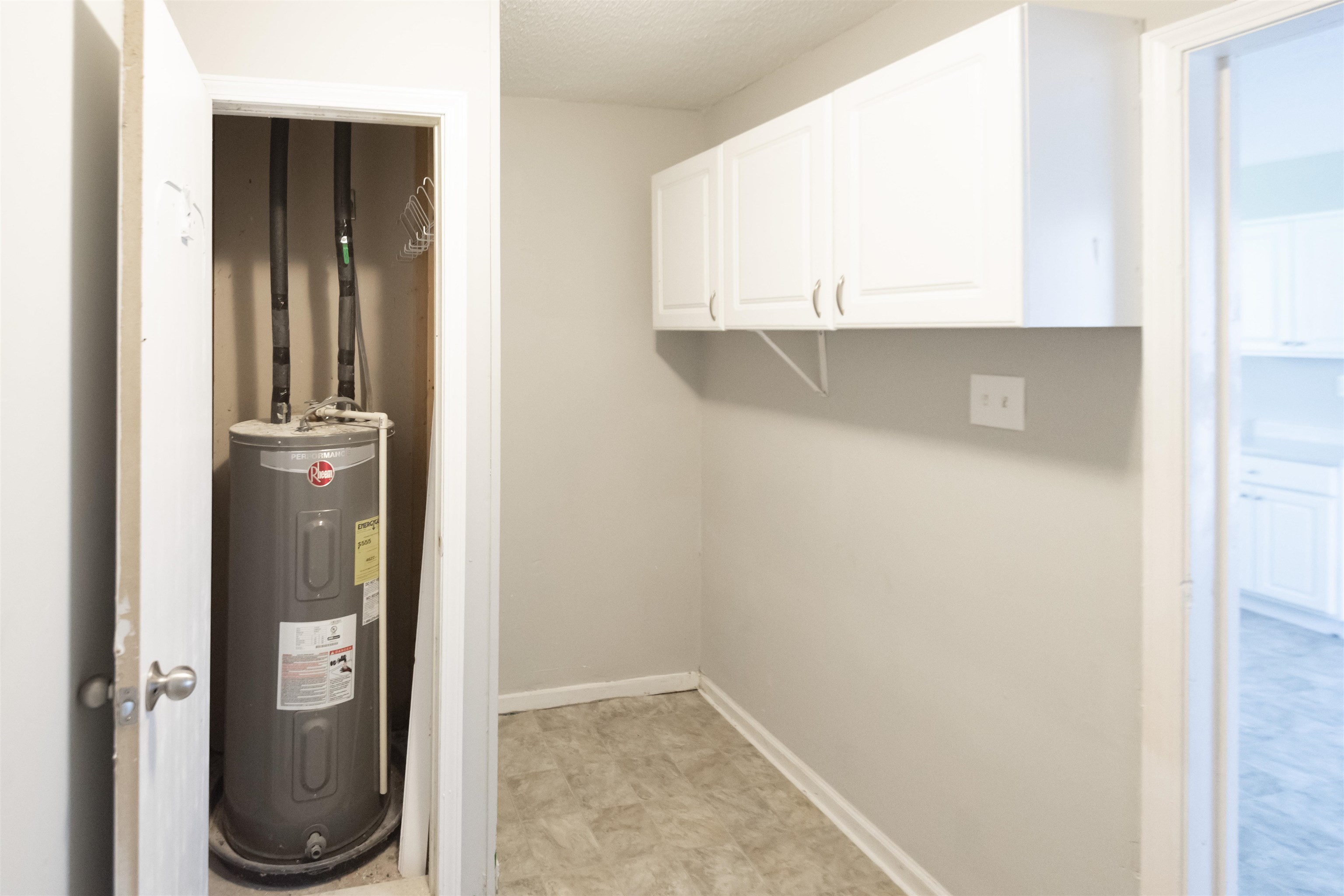 4399 Pepper Tree Road Memphis, TN 38109 - Photo 3 of 14 Built-in white cabinetry, light gray walls, and water heater
