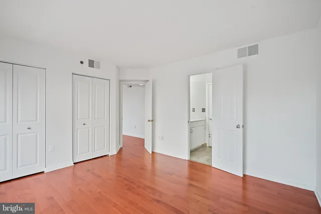 a view of an empty room with wooden floor