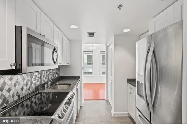 a kitchen with stainless steel appliances granite countertop a refrigerator and a stove