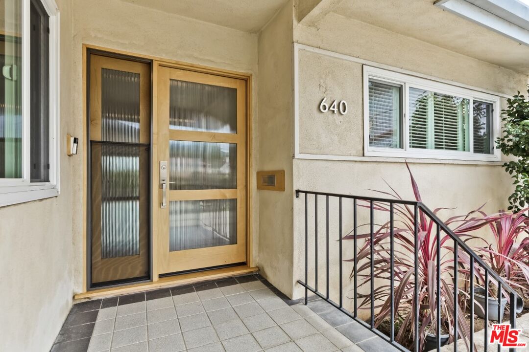 a view of a porch with a door and wooden floor