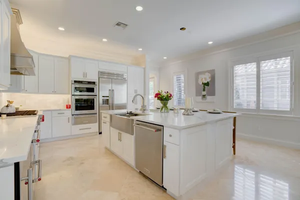 a kitchen with kitchen island cabinets and chairs in it