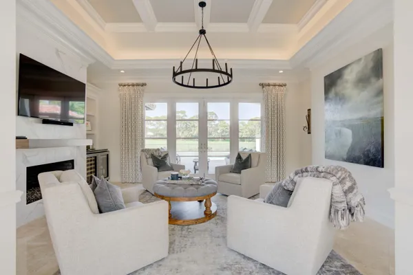 a living room with furniture a flat screen tv and a chandelier