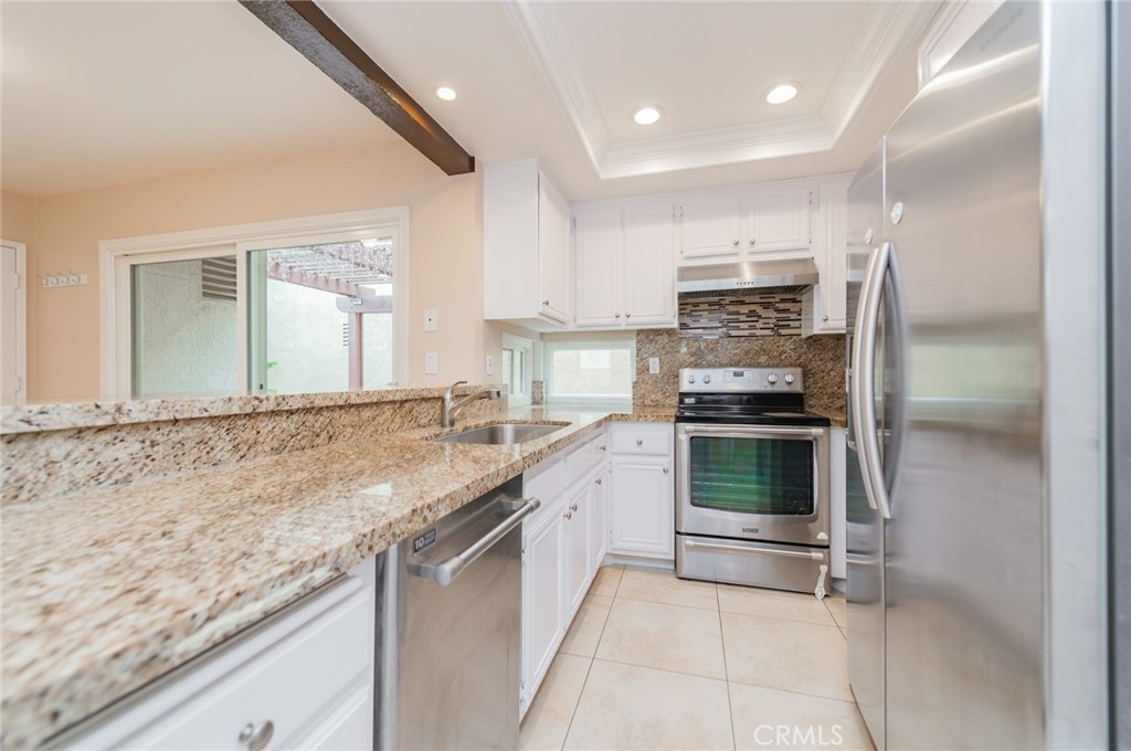7 Tivoli Irvine, CA 92620 - Photo 11 of 29 a kitchen with stainless steel appliances granite countertop a stove and a sink