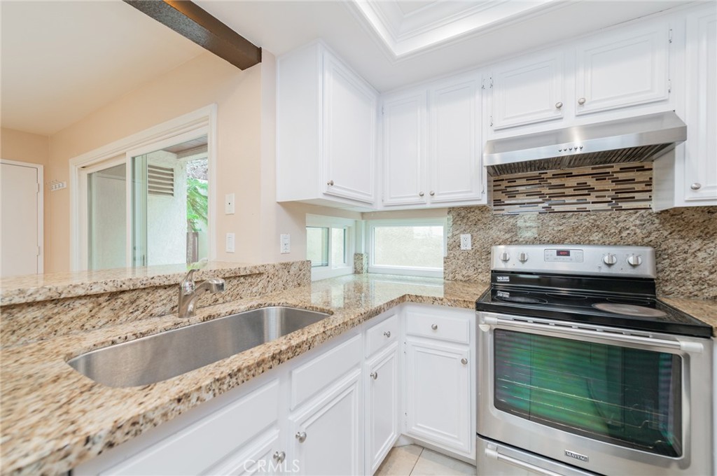 7 Tivoli Irvine, CA 92620 - Photo 12 of 29 a kitchen with granite countertop a stove sink and cabinets