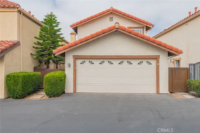 a view of a house with a small yard and garage