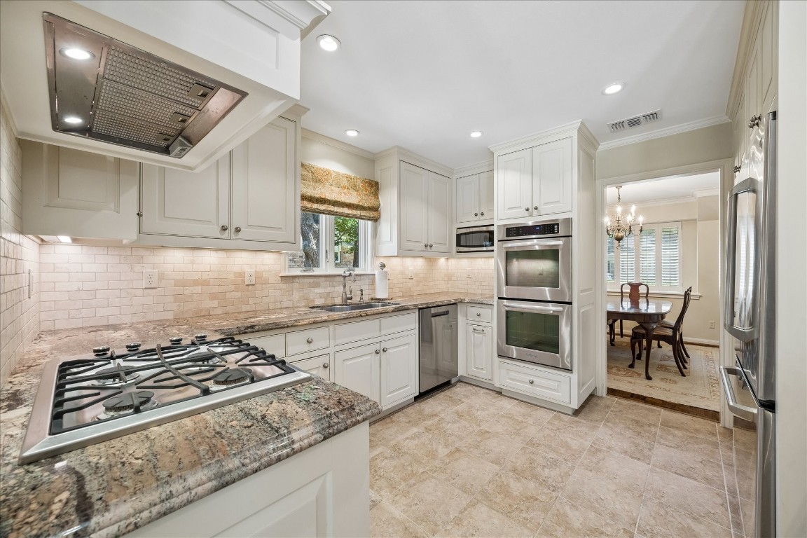 12206 Perthshire Road Houston, TX 77024 - Photo 9 of 30 Natural light shining into kitchen with double ovens and gas stovetop.