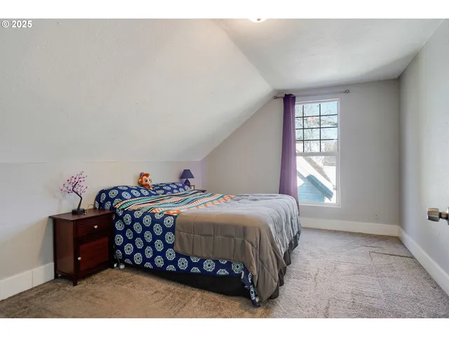 a bedroom with a bed window and a dresser