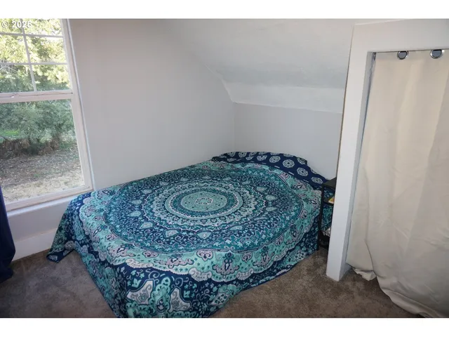 a bedroom with a bed and a painting on the wall