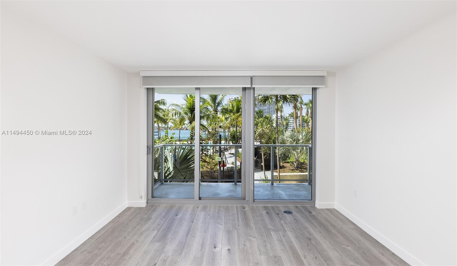 1500 Bay Road, Unit N0109 Miami Beach, FL 33139 - Photo 4 of 73 an empty room with wooden floor and windows
