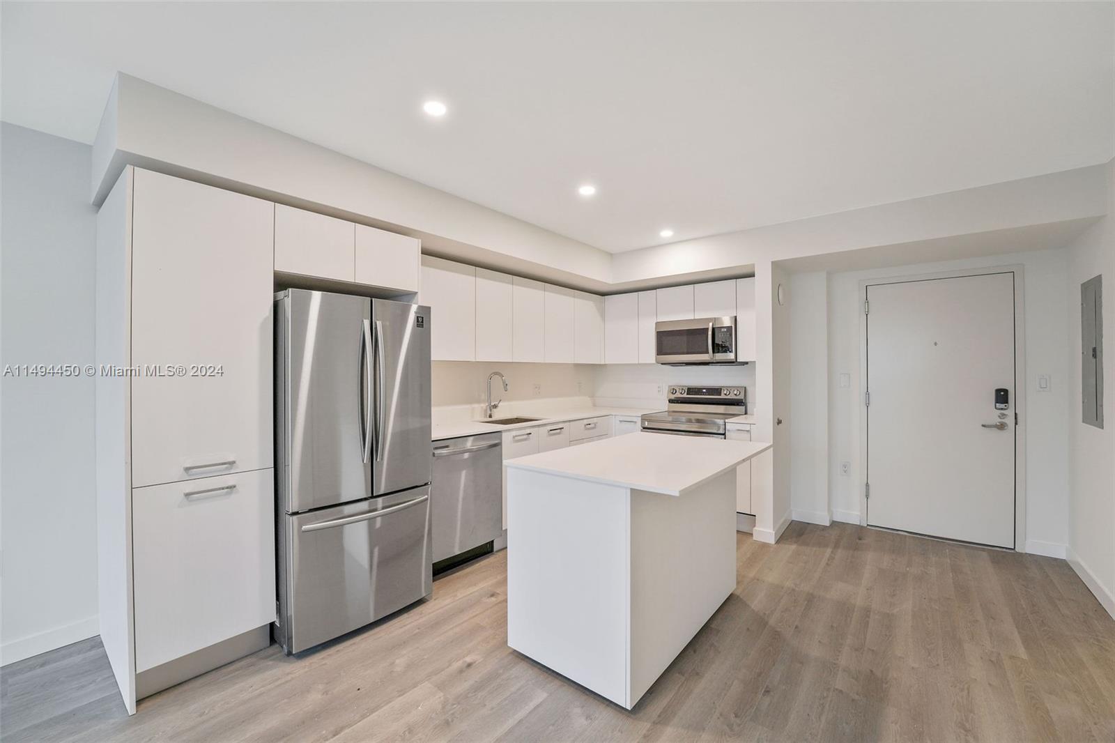 1500 Bay Road, Unit N0109 Miami Beach, FL 33139 - Photo 7 of 73 a kitchen with a refrigerator a stove top oven and white kitchen