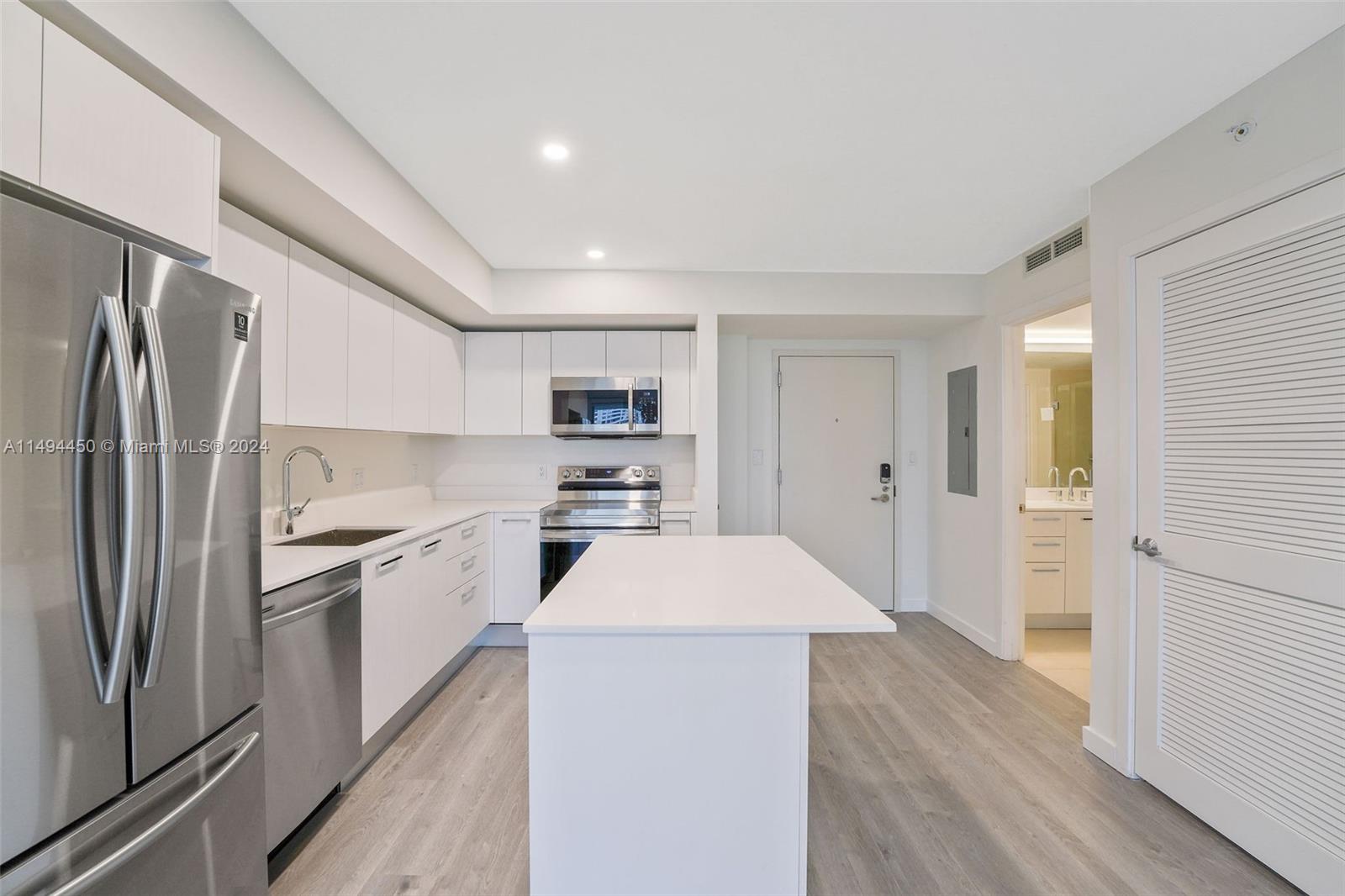 1500 Bay Road, Unit N0109 Miami Beach, FL 33139 - Photo 8 of 73 a kitchen with a refrigerator stove and wooden floor