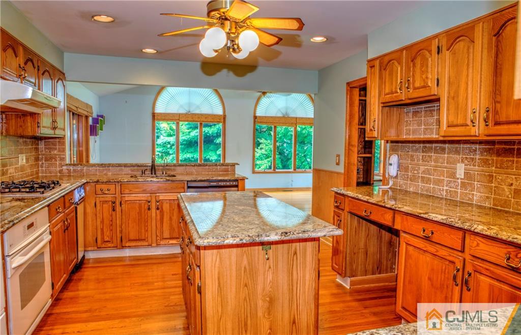 87 Harding Avenue Edison, NJ 08820 - Photo 6 of 25 a kitchen with stainless steel appliances granite countertop a sink and a wooden floors