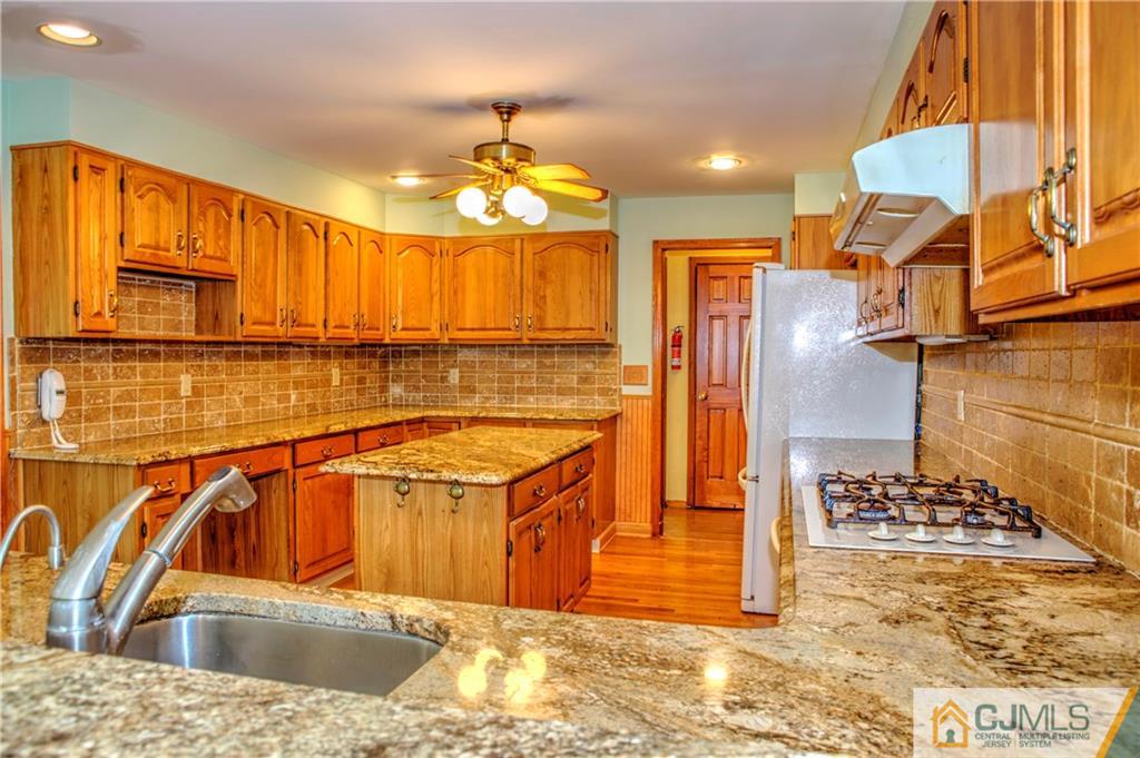 87 Harding Avenue Edison, NJ 08820 - Photo 7 of 25 a kitchen with stainless steel appliances kitchen island granite countertop a sink and cabinets