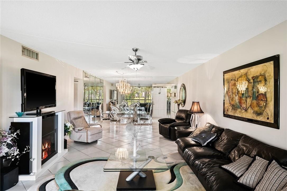 2661 South Course Drive, Unit 209 Pompano Beach, FL 33069 - Photo 12 of 21 a living room with furniture and a flat screen tv