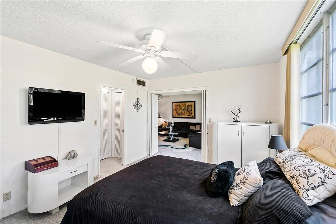 2661 South Course Drive, Unit 209 Pompano Beach, FL 33069 - Photo 14 of 21 a bedroom with furniture and a flat screen tv