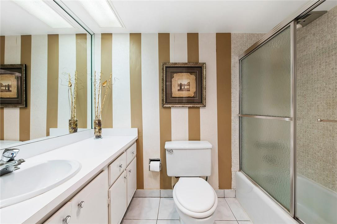 2661 South Course Drive, Unit 209 Pompano Beach, FL 33069 - Photo 19 of 21 a bathroom with a toilet sink and a mirror