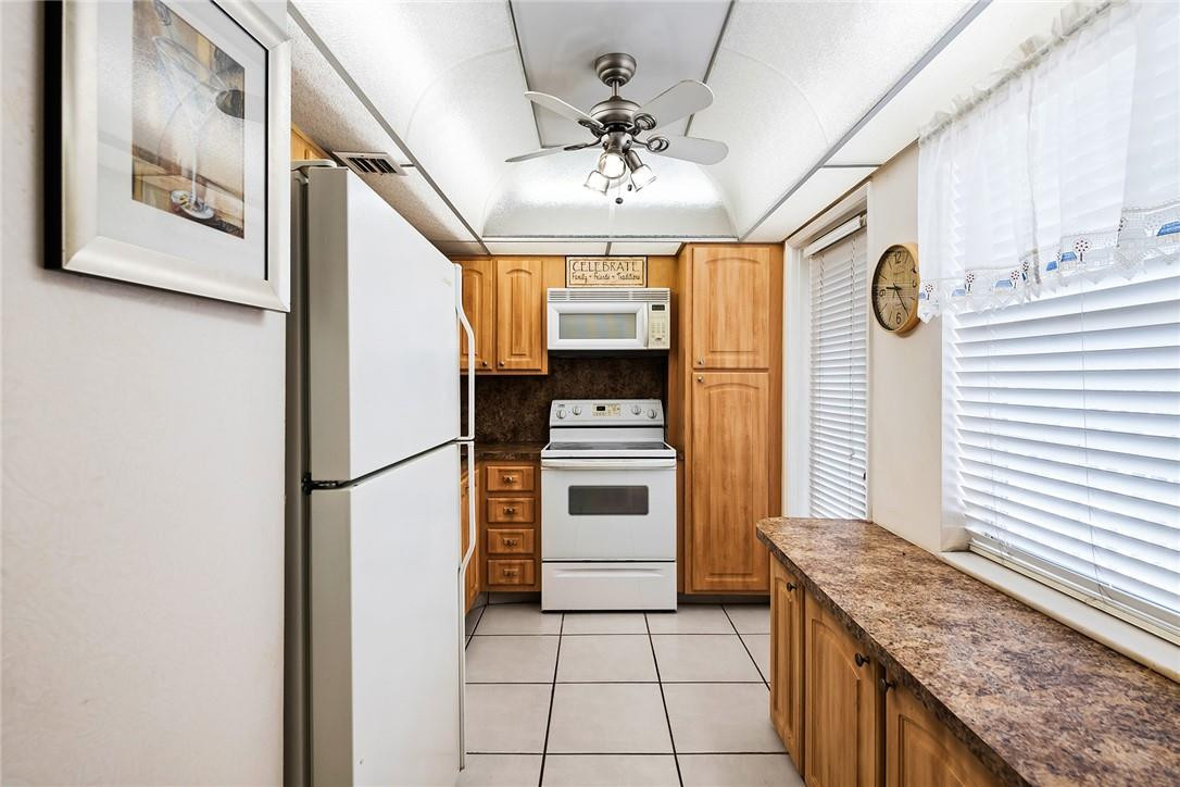 2661 South Course Drive, Unit 209 Pompano Beach, FL 33069 - Photo 2 of 21 a kitchen with stainless steel appliances granite countertop a refrigerator and a stove