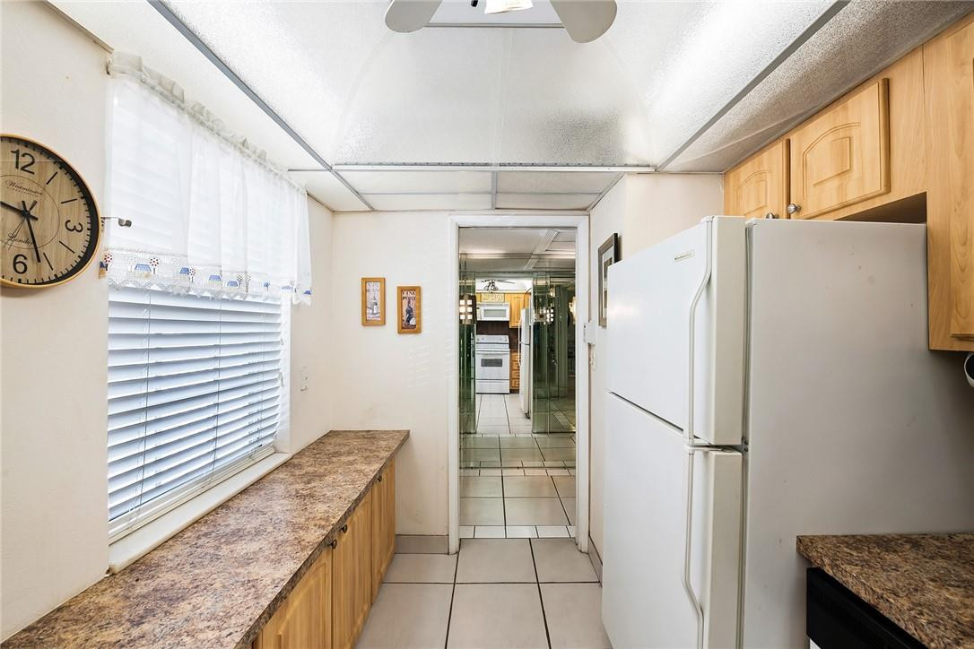2661 South Course Drive, Unit 209 Pompano Beach, FL 33069 - Photo 4 of 21 a kitchen with granite countertop a refrigerator and a stove