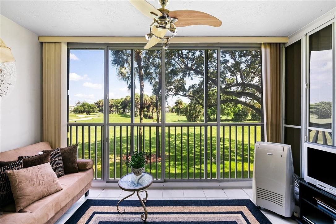 2661 South Course Drive, Unit 209 Pompano Beach, FL 33069 - Photo 5 of 21 a living room with furniture and a floor to ceiling window