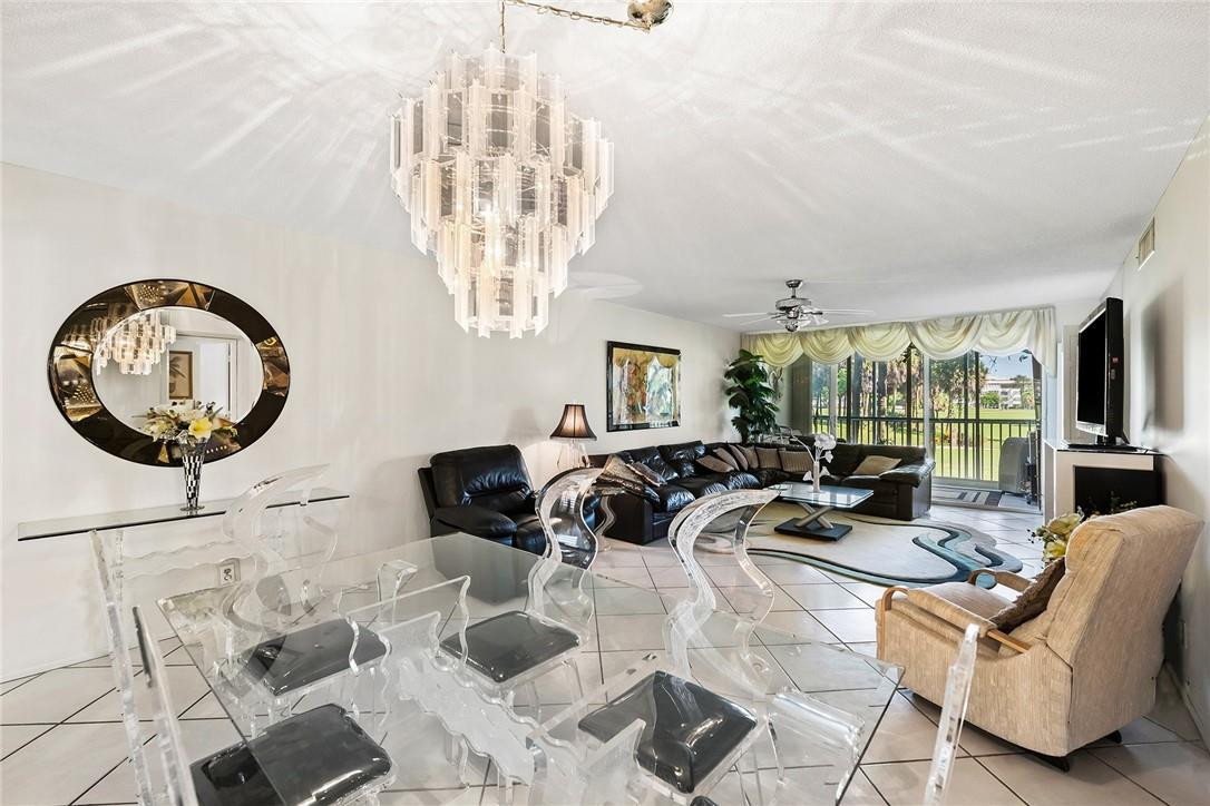 2661 South Course Drive, Unit 209 Pompano Beach, FL 33069 - Photo 8 of 21 a living room with furniture a chandelier and a large mirror