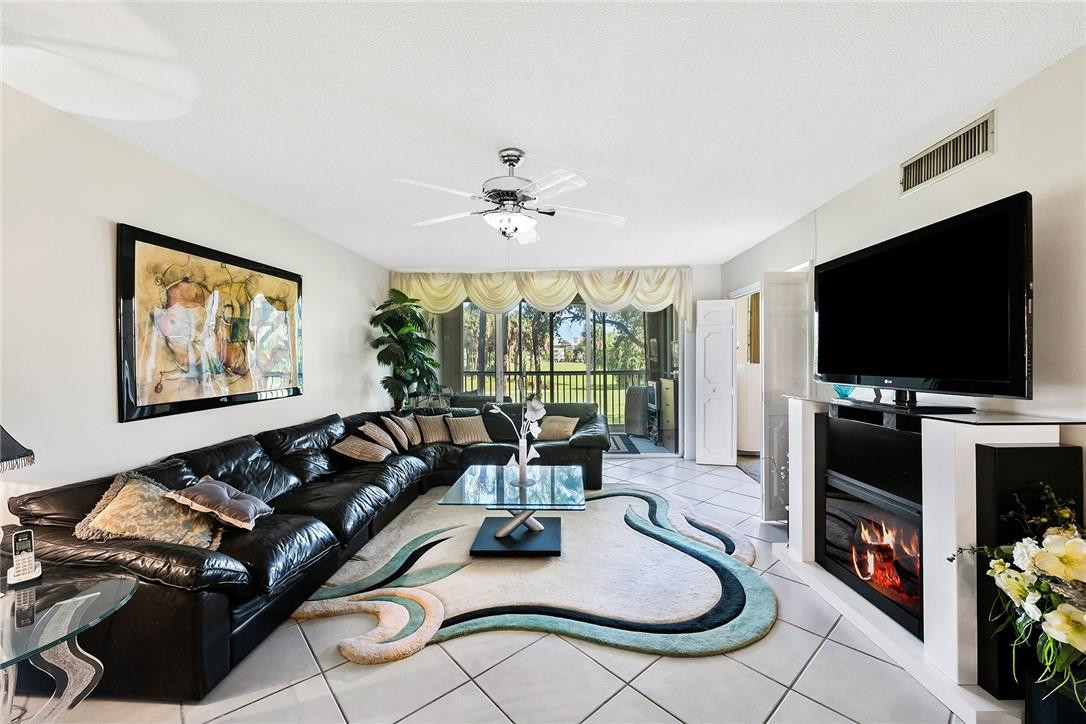 2661 South Course Drive, Unit 209 Pompano Beach, FL 33069 - Photo 9 of 21 a living room with furniture and a flat screen tv