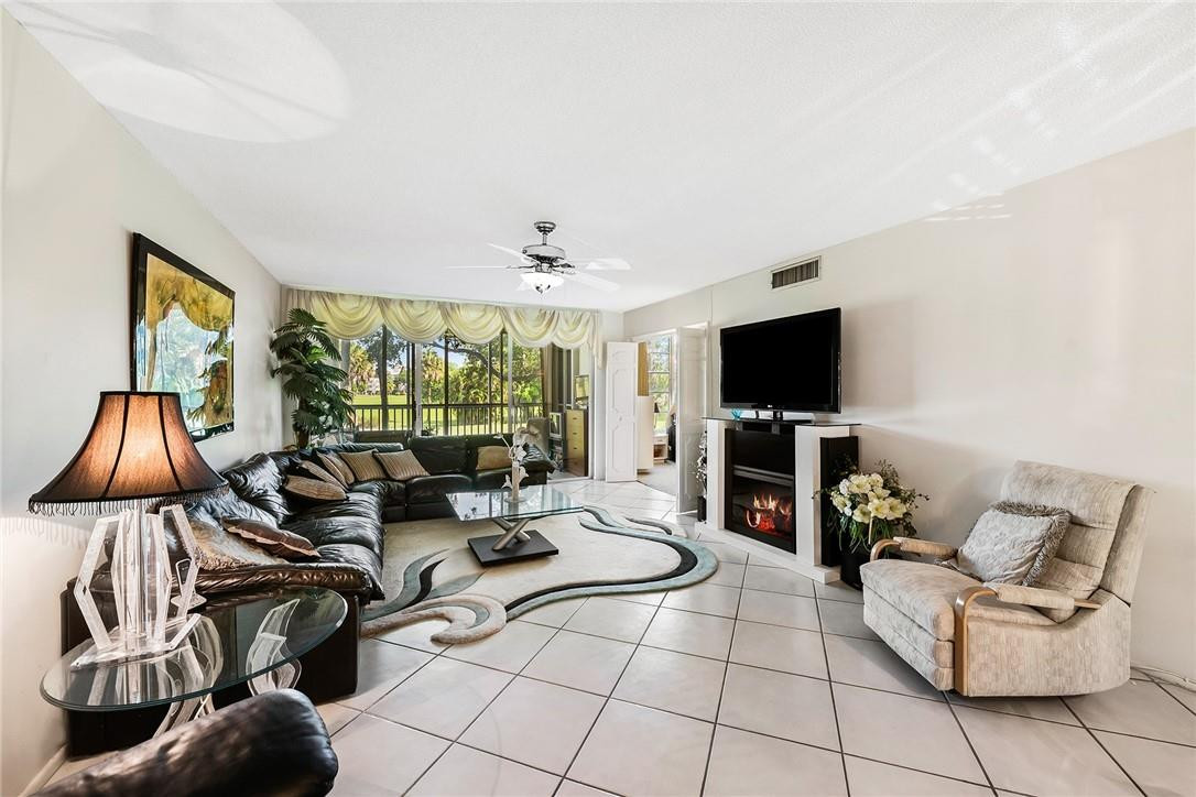 2661 South Course Drive, Unit 209 Pompano Beach, FL 33069 - Photo 10 of 21 a living room with fireplace furniture and a flat screen tv