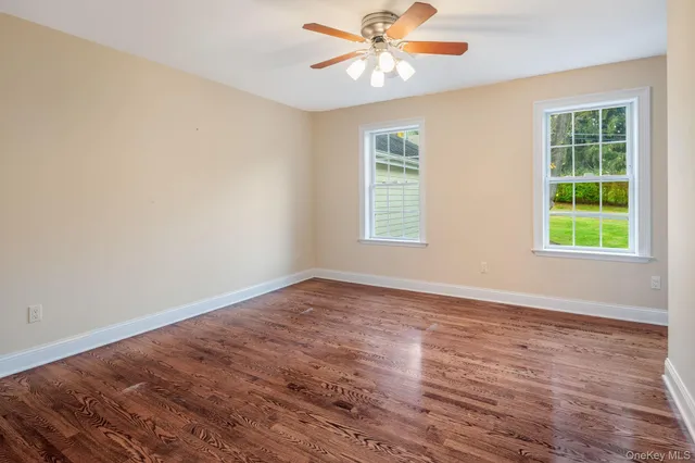 a bathroom with a granite countertop sink a toilet a mirror and a window