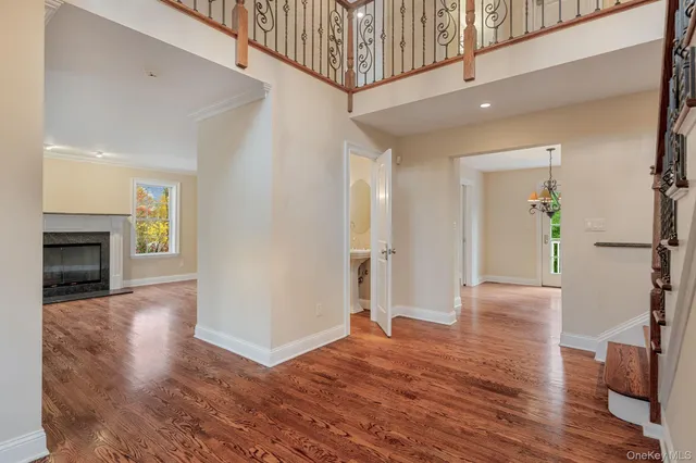 a view of an empty room with wooden floor and a fireplace