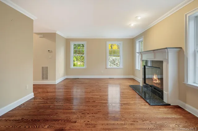 a view of an empty room with a fireplace and a window