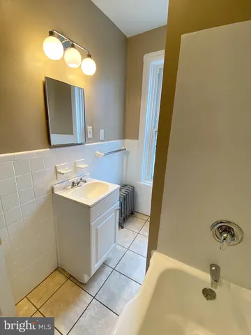 a bathroom with a tub sink and mirror