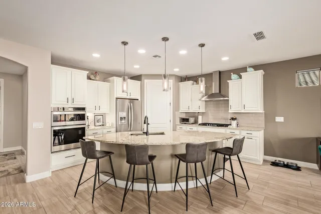 a kitchen with kitchen island wooden cabinets and refrigerator