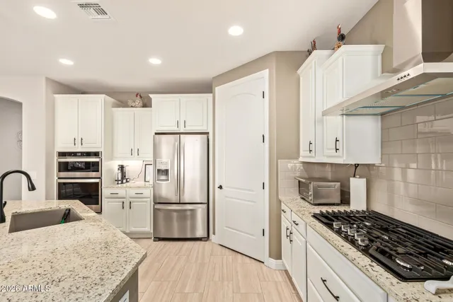 a kitchen with granite countertop a sink stove and refrigerator