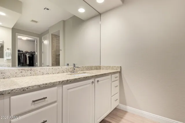 a bathroom with a granite countertop sink and a mirror