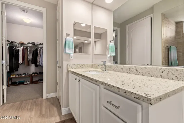 a bathroom with a granite countertop sink and a mirror