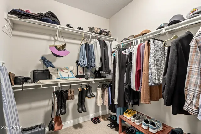 a view of walk in closet with clothes and shoes