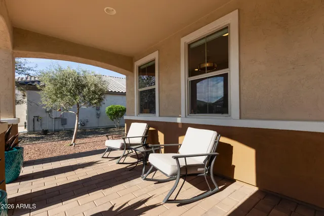 a patio with glass top table and chairs