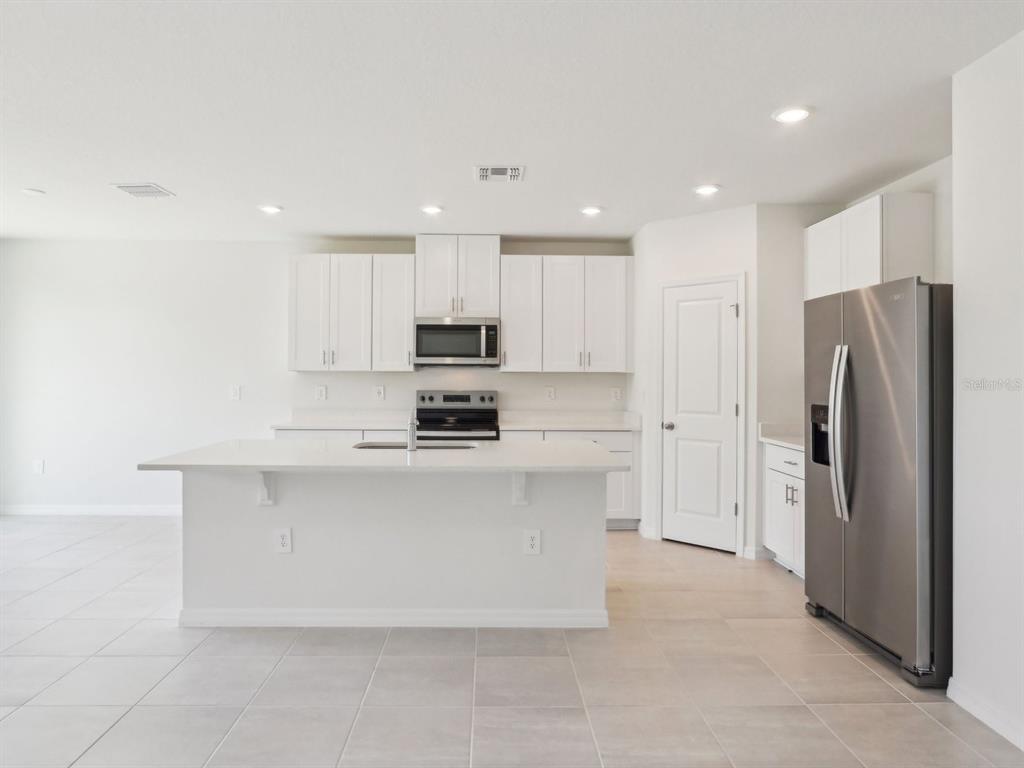 1643 Bark Rdg Drive Auburndale, FL 33823 - Photo 8 of 31 a kitchen with stainless steel appliances a refrigerator sink and microwave