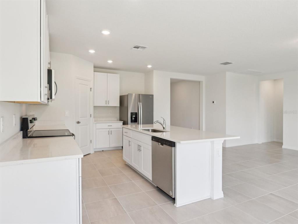 1643 Bark Rdg Drive Auburndale, FL 33823 - Photo 9 of 31 a kitchen with white cabinets and stainless steel appliances