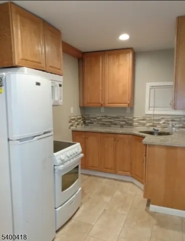a kitchen with granite countertop cabinets and refrigerator