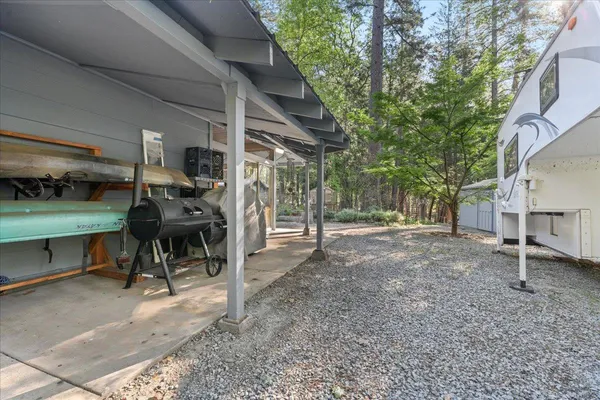 a view of a house with a yard and a large tree