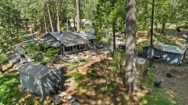an aerial view of residential house with outdoor space and trees all around
