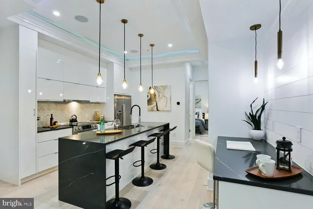 a kitchen with stainless steel appliances kitchen island a table and chairs in it