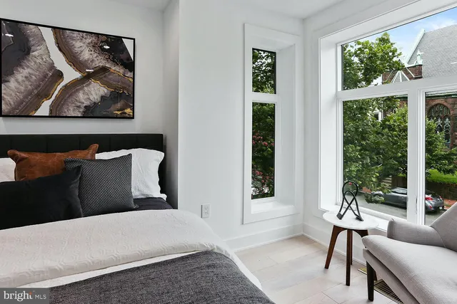 a bedroom with a bed and a painting on the wall