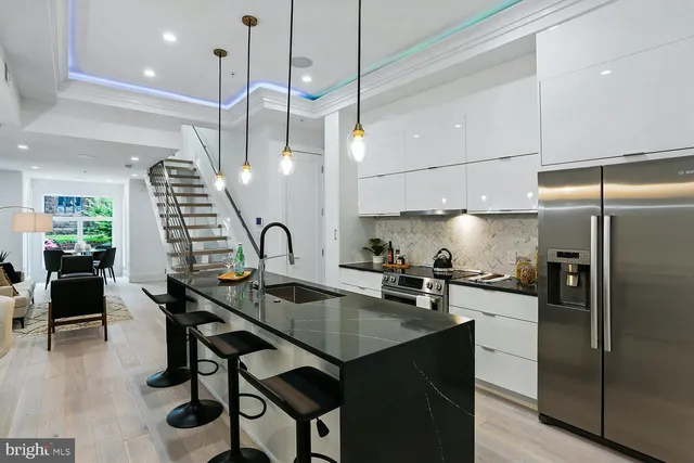 a kitchen with granite countertop a table chairs stainless steel appliances and cabinets