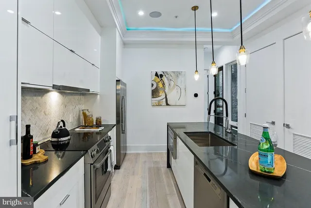 a kitchen with sink refrigerator and stove