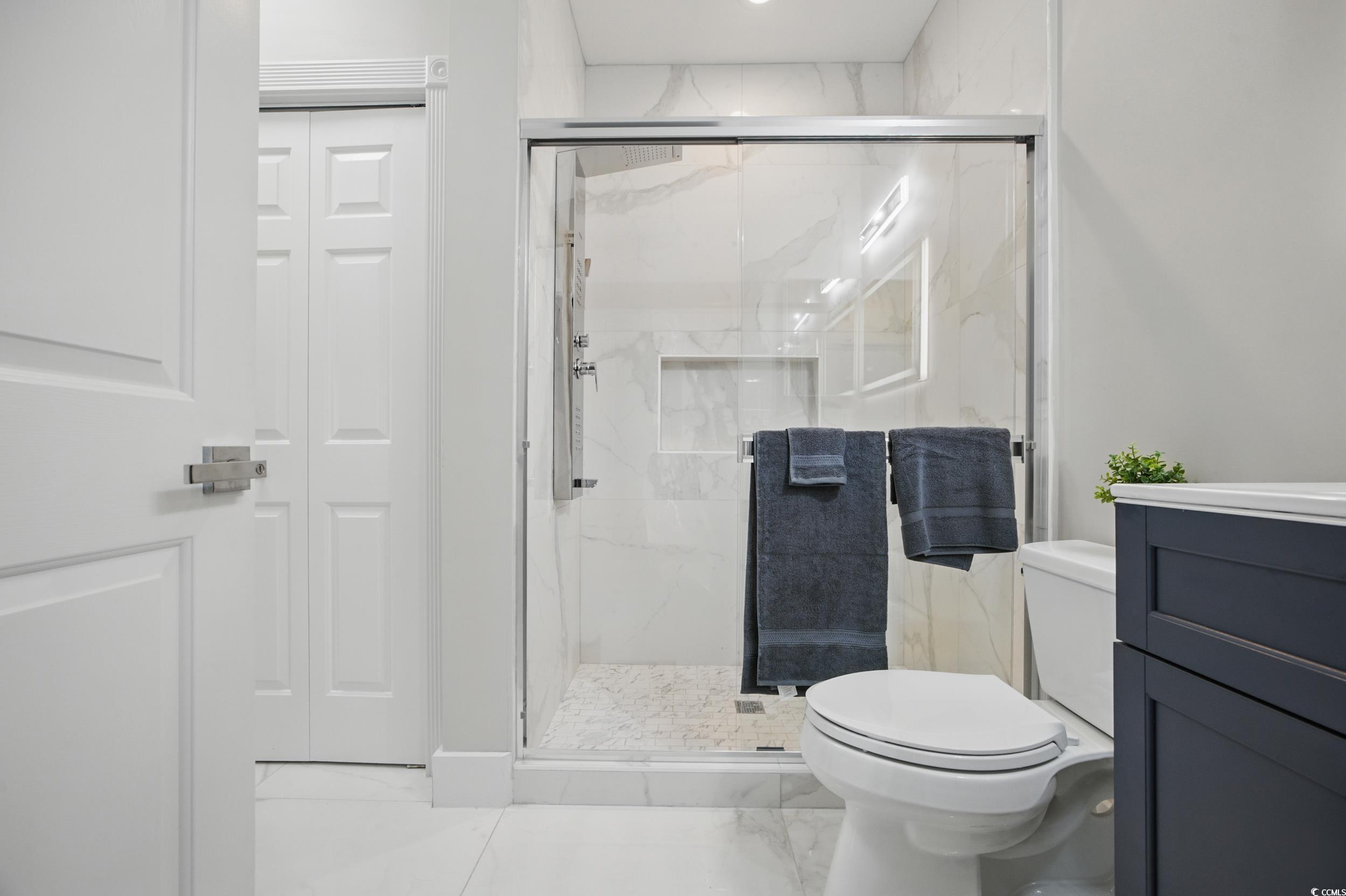 4821 Luster Leaf Circle, Unit 101 Myrtle Beach, SC 29577 - Photo 11 of 30 Bathroom featuring a closet, marble finish flooring, and a marble finish shower
