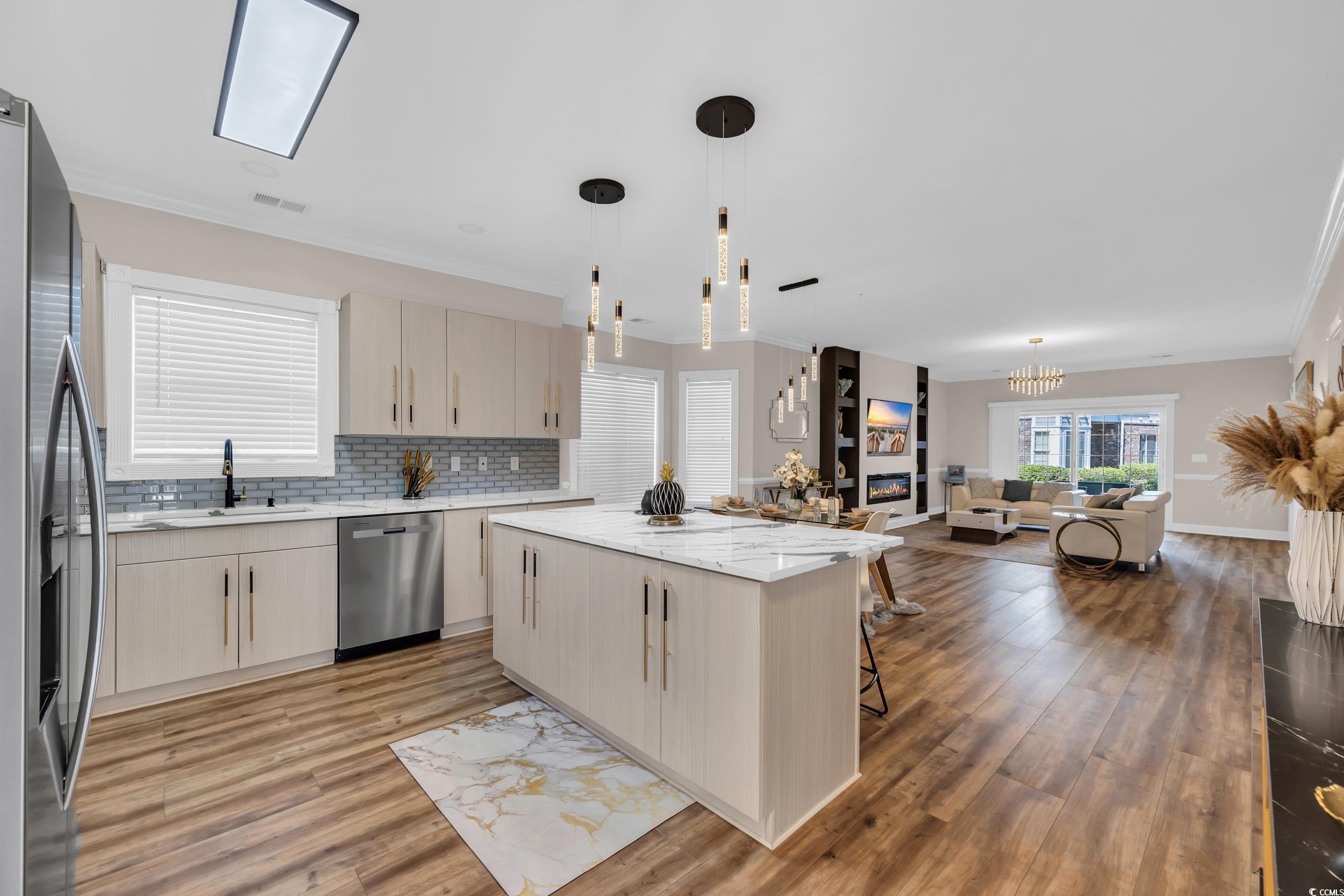 4821 Luster Leaf Circle, Unit 101 Myrtle Beach, SC 29577 - Photo 30 of 30 Kitchen featuring open floor plan, light stone countertops, light brown cabinets, crown molding, and a kitchen breakfast bar