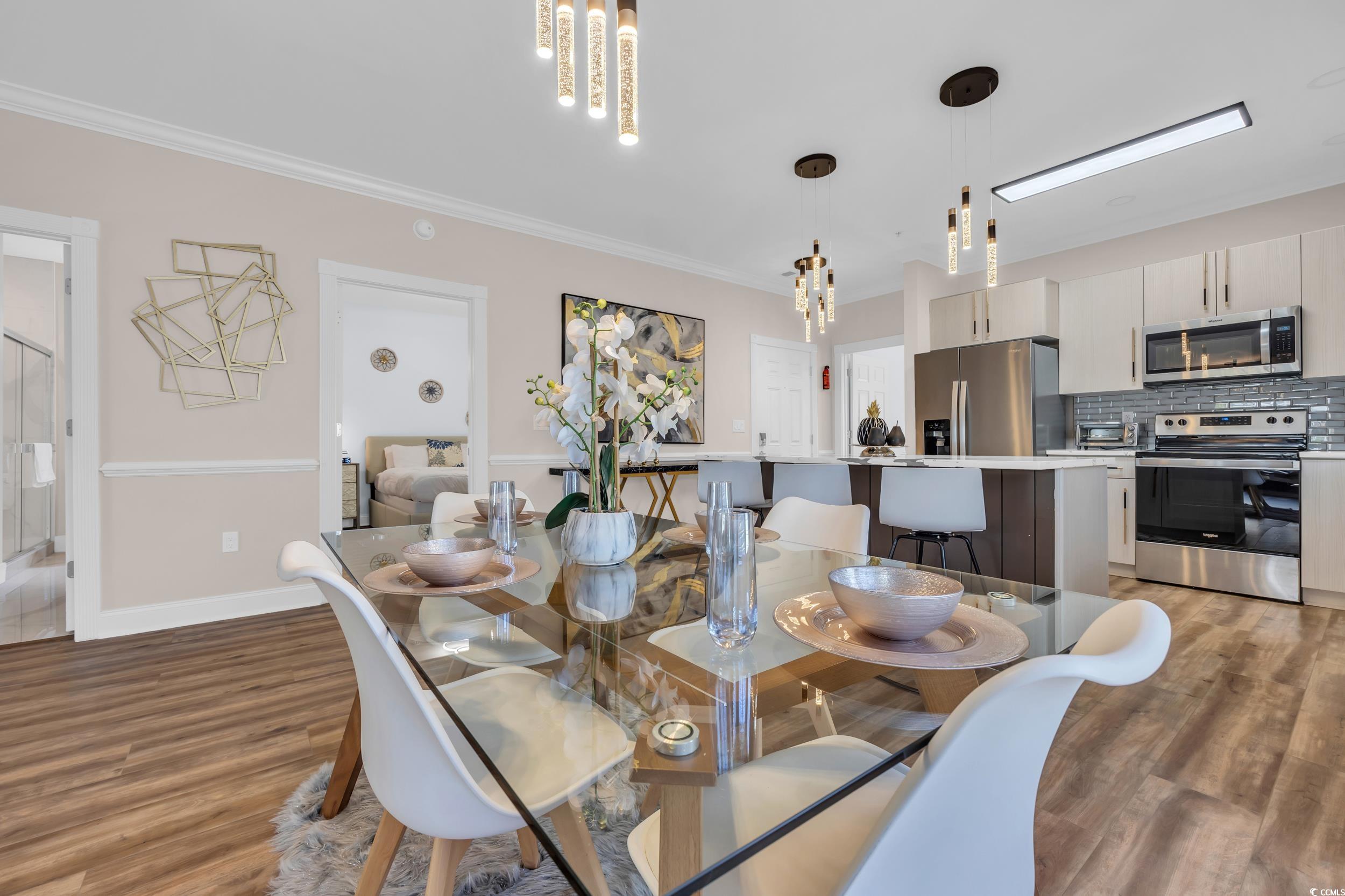 4821 Luster Leaf Circle, Unit 101 Myrtle Beach, SC 29577 - Photo 19 of 30 Dining space with crown molding and light wood-style flooring